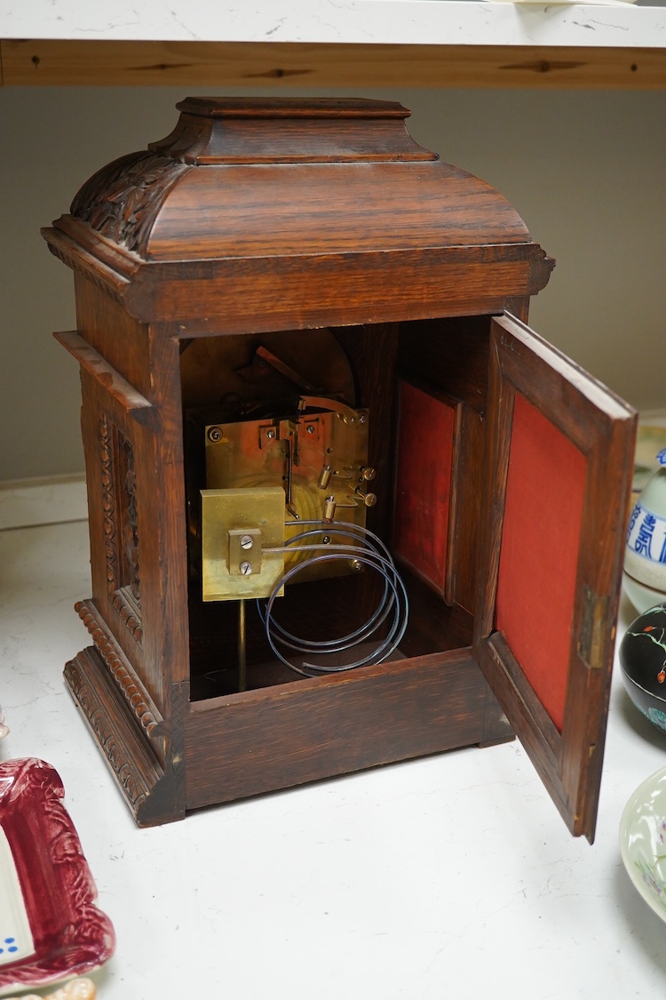 A Victorian carved oak bracket clock, the dial inscribed Goodsmiths Company, with pendulum and keys, 42cm high
